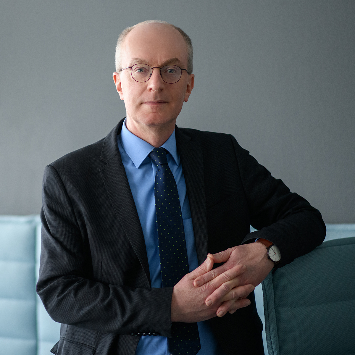 Portraitbild von Prof. Dr. Friedrich Heinemann sitzend auf einem hellblauen Sofa