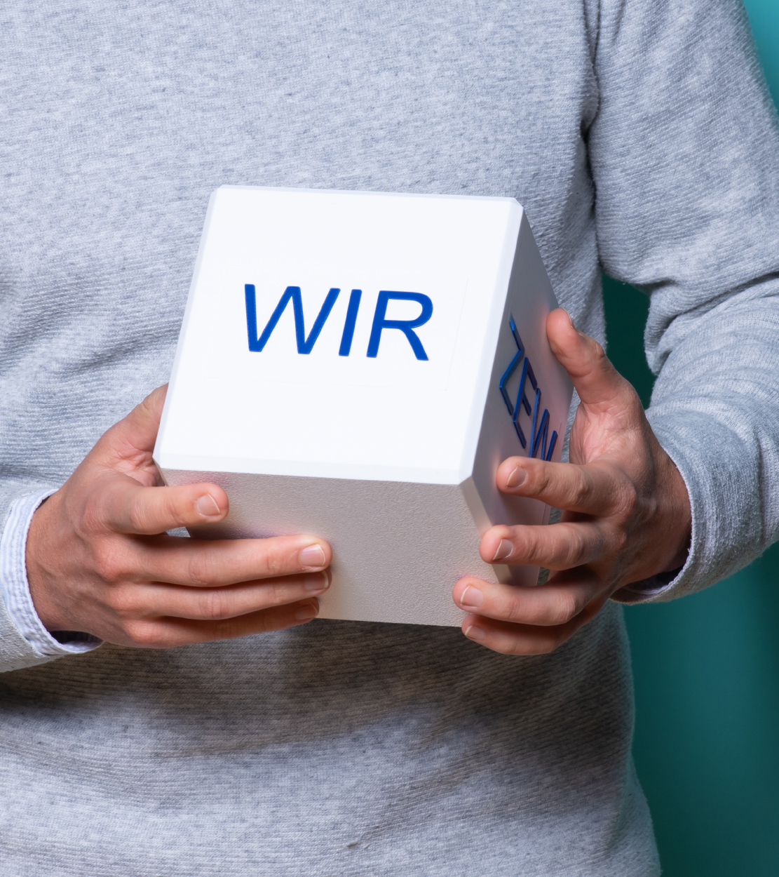 Bild mit Menschen, die einen Würfel halten
