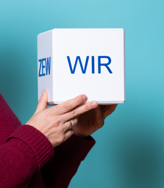 Bild mit Menschen, die einen Würfel halten