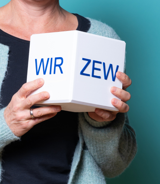 Bild mit Menschen, die einen Würfel halten