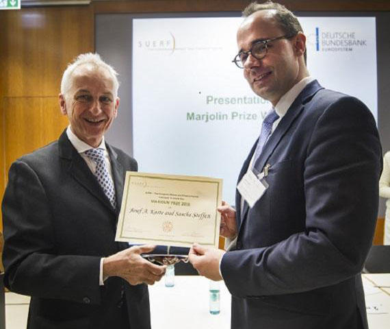 Prof. Dr. Sascha Steffen (r.) nimmt die Urkunde von Prof. Dr. Urs Birchler von der Universität Zürich entgegen.