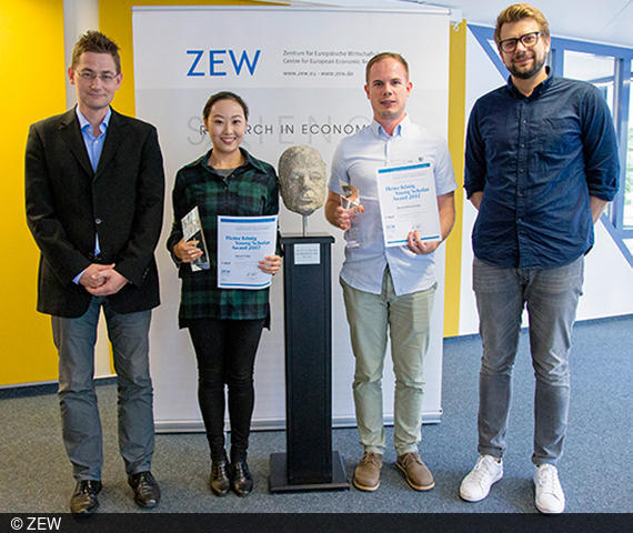 ZEW Research Group Heads Kai Hüschelrath (l.) and Vitali Gretschko (r.) with the winners Jiekai Zhang and Bernhard Kasberger. 