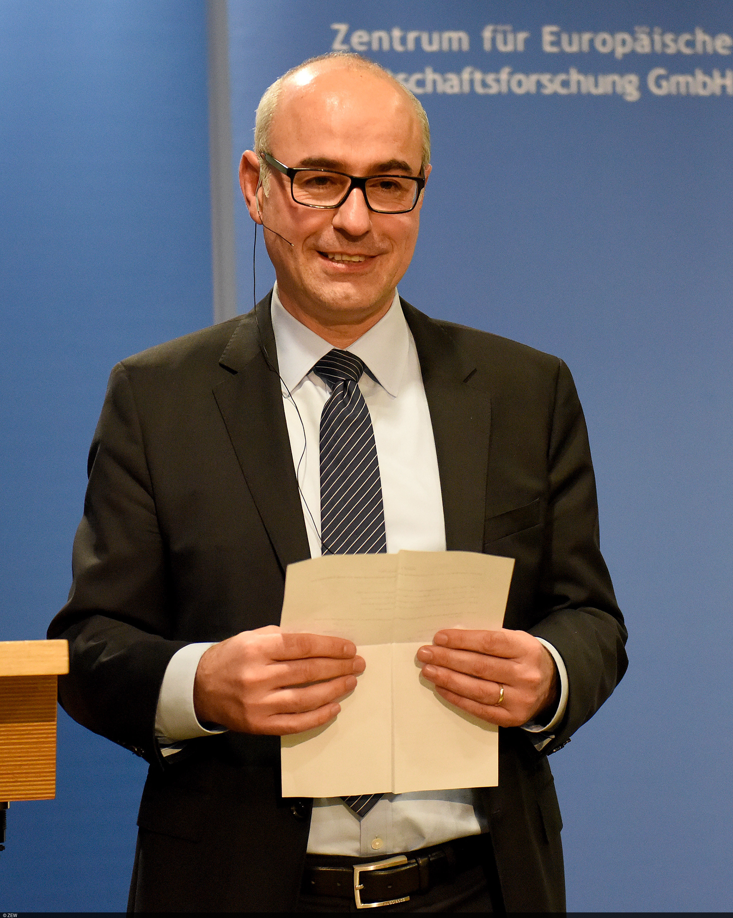 ZEW President Achim Wambach stands on the podium and welcomes speakers and guests at the ZEW