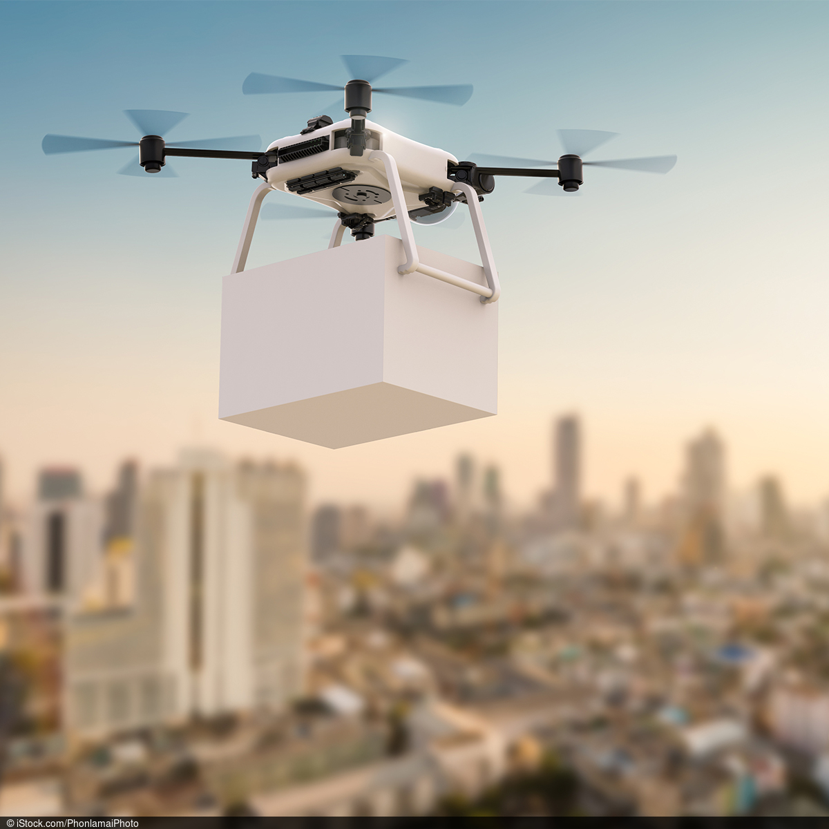 Bild eine Drohne mit einem Paket vor einer Stadt