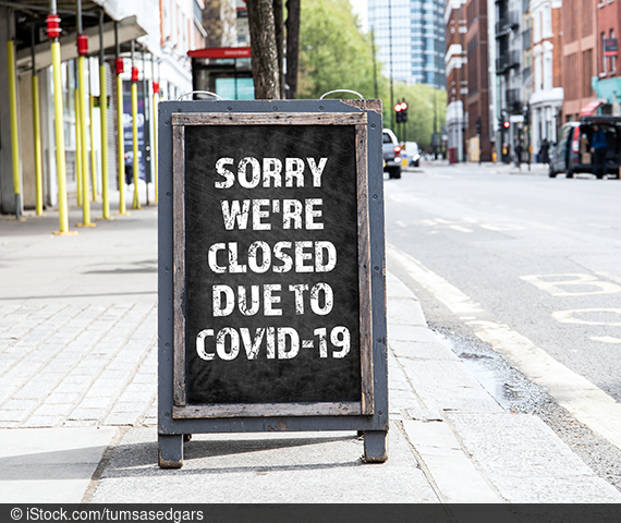 Picture of a written board on a sidewalk.
