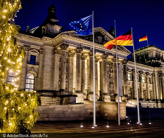 Das Reichstagsgebäude im Hintergrund, Europa- und Deutschland-Fahne im Vordergrund
