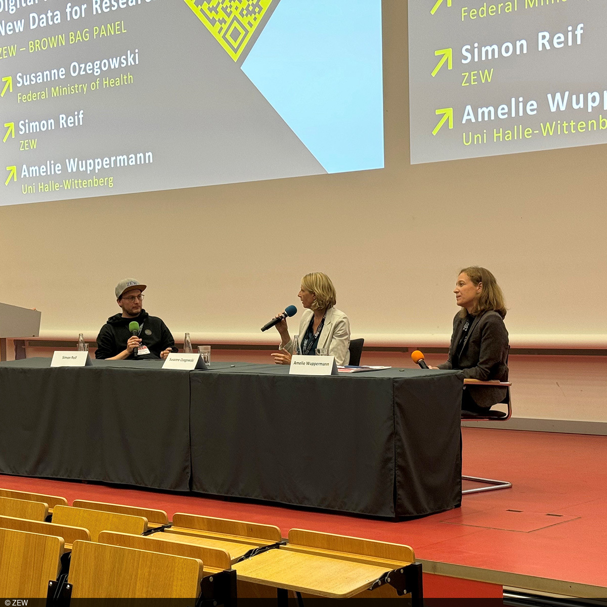 On the podium are (from left) Simon Reif, Susanne Ozigowski and Amelie Wuppermann.