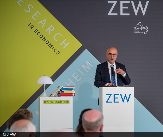  ZEW President Achim Wambach stands at a podium 
