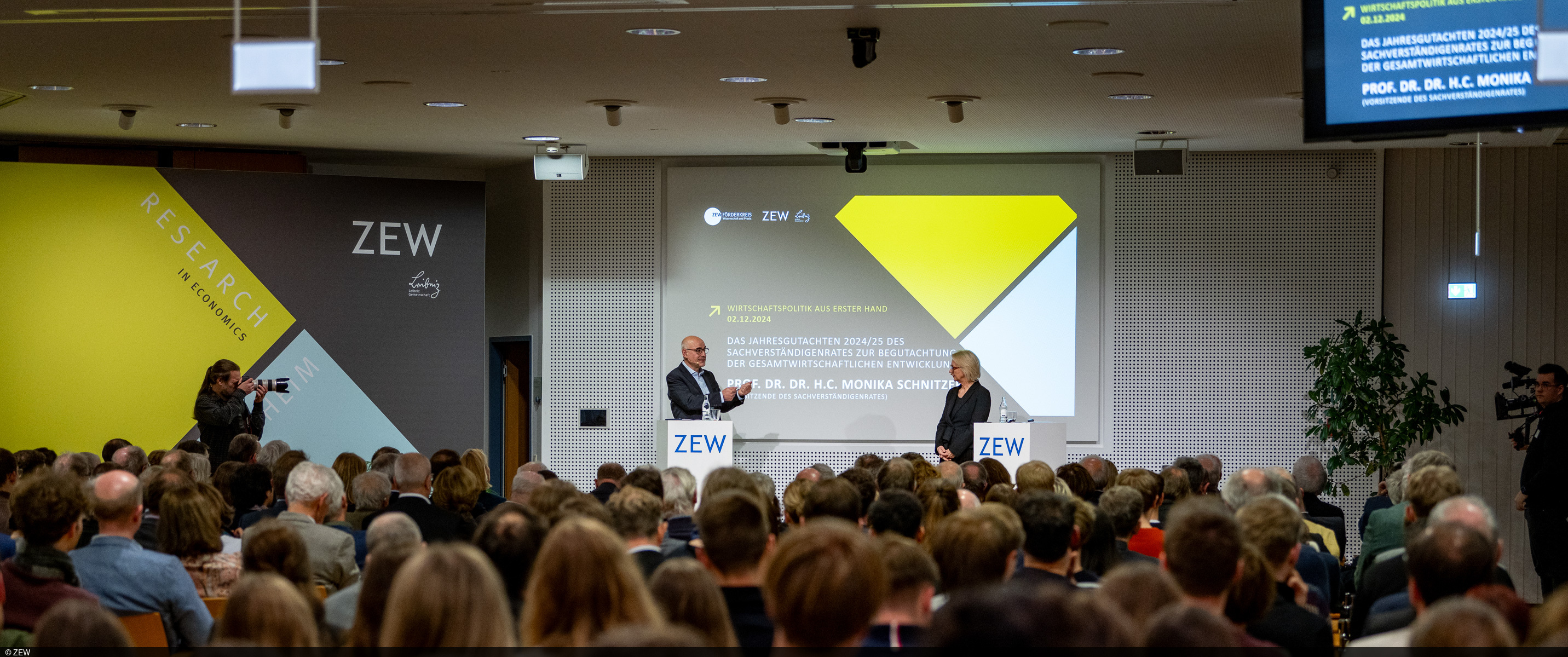 Das Bild zeigt Achim Wambach und Monika Schnitzer bei der Diskussion.