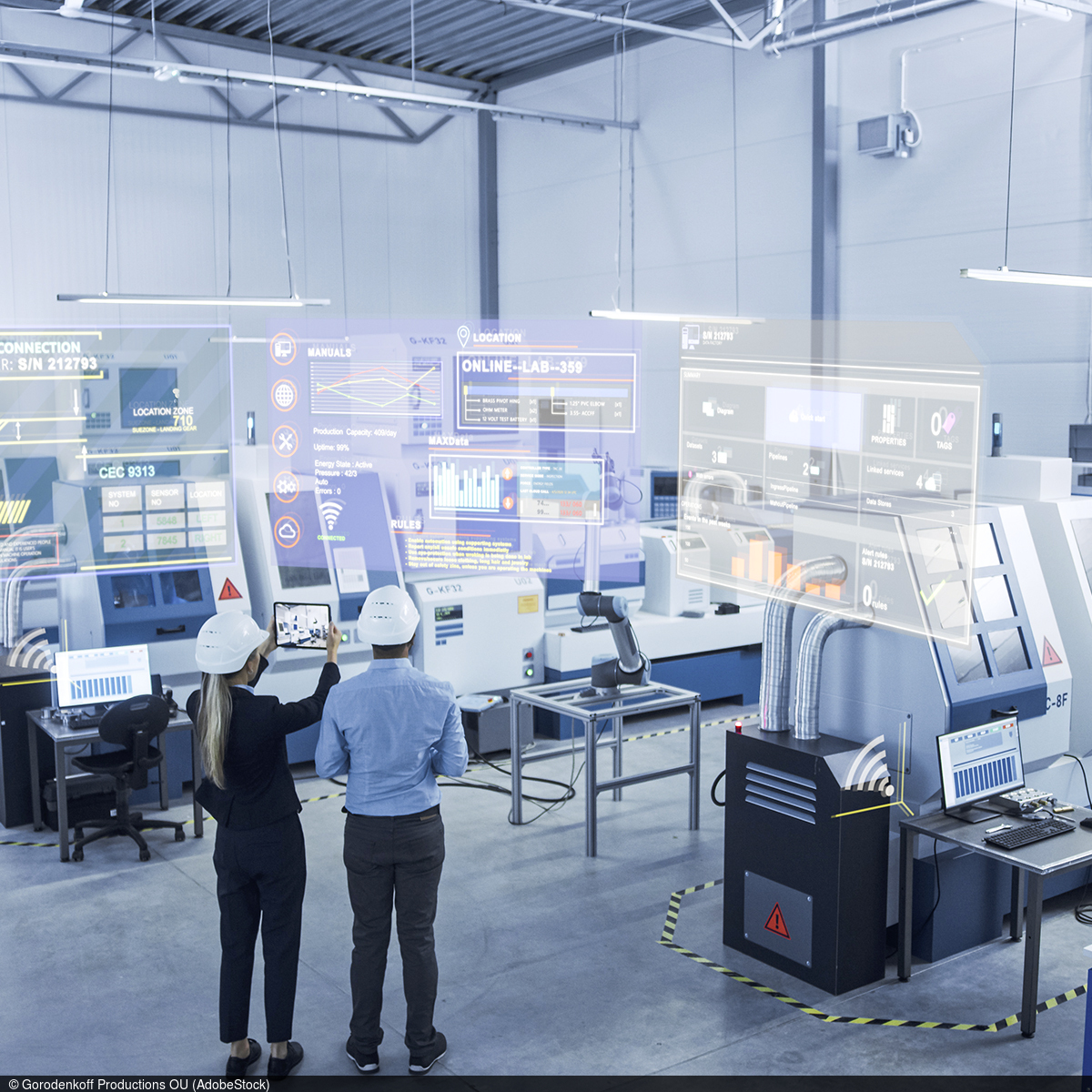 Two people stand in a high-tech production plant